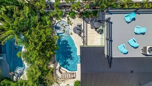 Un área de piscina en la azotea con sillones de descanso y una piscina circular pequeña.