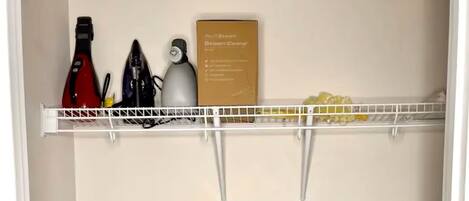 A closet with shelves holding cleaning supplies and a vacuum cleaner.