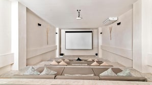 Un système de cinéma maison moderne doté d’un grand écran, de sièges confortables et d’un design minimaliste.