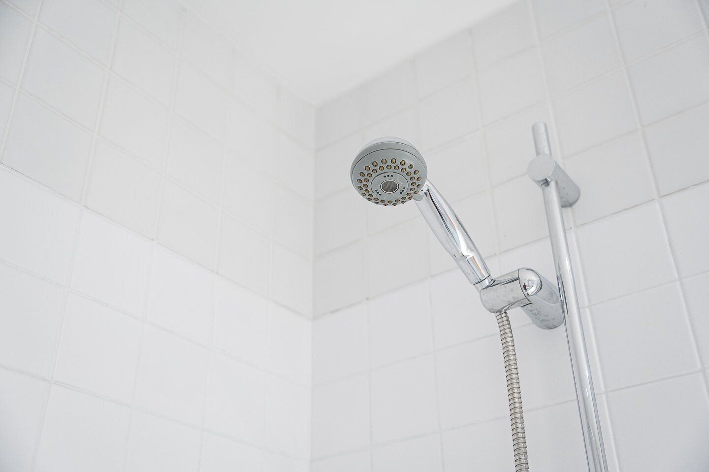A showerhead with a rain shower attachment, a handheld showerhead, and a flexible hose.