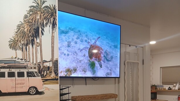 A living room with a television displaying a sea turtle, a dining table with chairs, a kitchen area, and a view of a pink van outside. - Perfect studio: solo, couple or family+kids.
Sleeps 4 adults comfortably + crib (El Cajon)