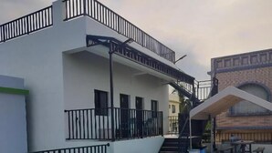 Terraza en la azotea con sillones azules y una zona de estar cubierta.