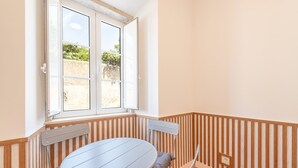A corner room with a window, a round table, and a chair. - Guestready - Urban Garden Apartments (Lisbon)