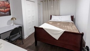 A bedroom with a bed, a desk, a chair, a wardrobe, and a painting on the wall. - A-136 Apartment 3 and 1/2 (bedroom, living room, kitchen, shower, washer-dryer) (Trois-Rivières)