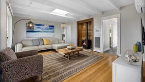 Una sala de estar moderna con un sofá, sillones, una mesa de centro y una chimenea.