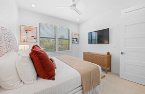 A bedroom with a bed, a wooden dresser, a television, and artwork on the walls. - Luxury Lido Escape w/ Pool, Slide, Spa & Rooftop! (Sarasota)