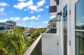 A balcony with a view of a residential area, including houses and palm trees. - Luxury Lido Escape w/ Pool, Slide, Spa & Rooftop! (Sarasota)