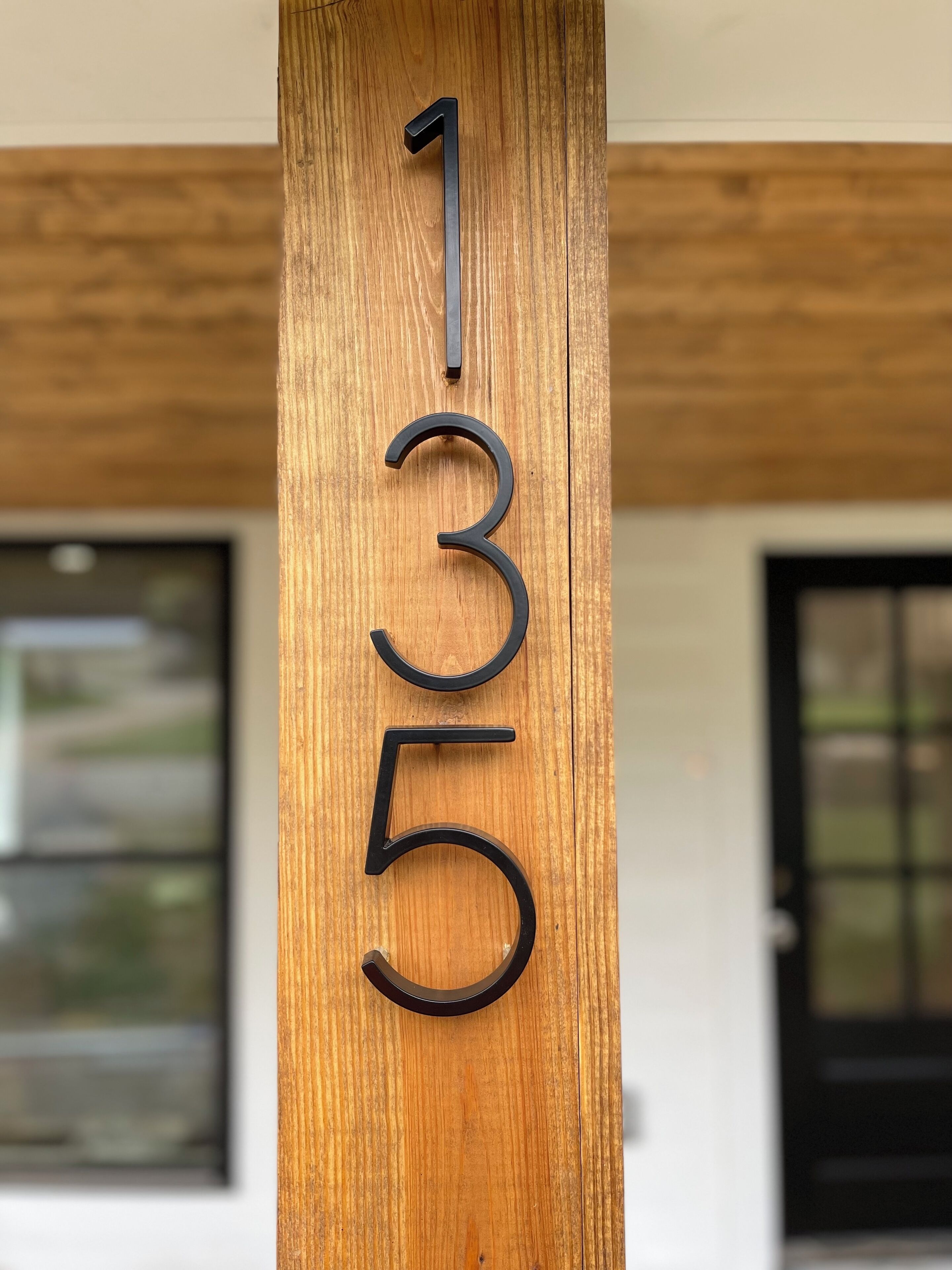 Un poteau en bois sur lequel sont gravés les chiffres 1355.