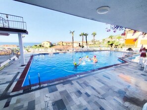 Una piscina interior con vistas al mar y palmeras.