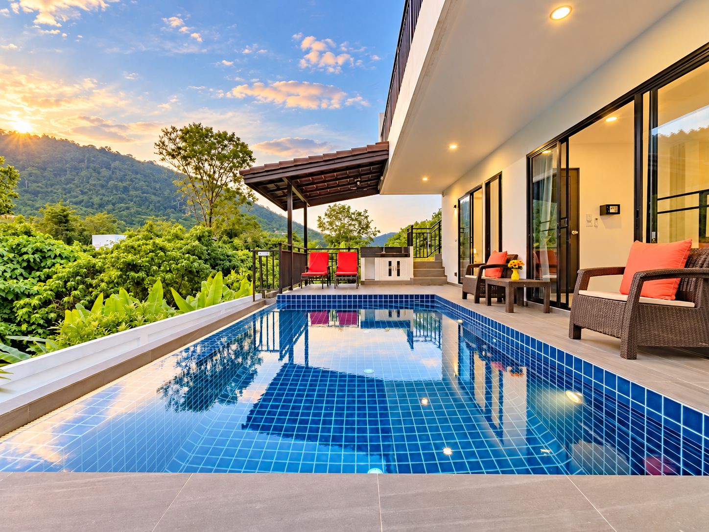 A modern outdoor swimming pool with a view of a mountainous landscape.