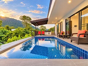 Une piscine extérieure moderne offrant une vue sur un paysage montagneux.