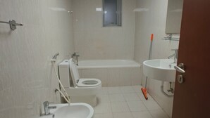 Casa de banho com sanita, bidé, banheira e lavatório.