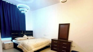 Um quarto moderno com uma cama, mesas de cabeceira, cômoda e luminária no teto.