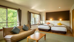 A hotel room with a sofa, two single beds, a wooden table, and large windows with curtains. - KKR Zao Hakuginso (Yamagata)