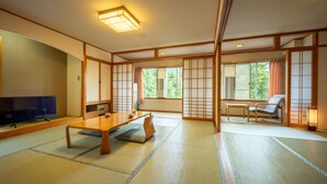 A traditional Japanese room with tatami flooring, a low table, a television, and sliding doors. - KKR Zao Hakuginso (Yamagata)