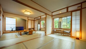 A traditional Japanese room with tatami flooring, a television, a sofa, and sliding doors. - KKR Zao Hakuginso (Yamagata)