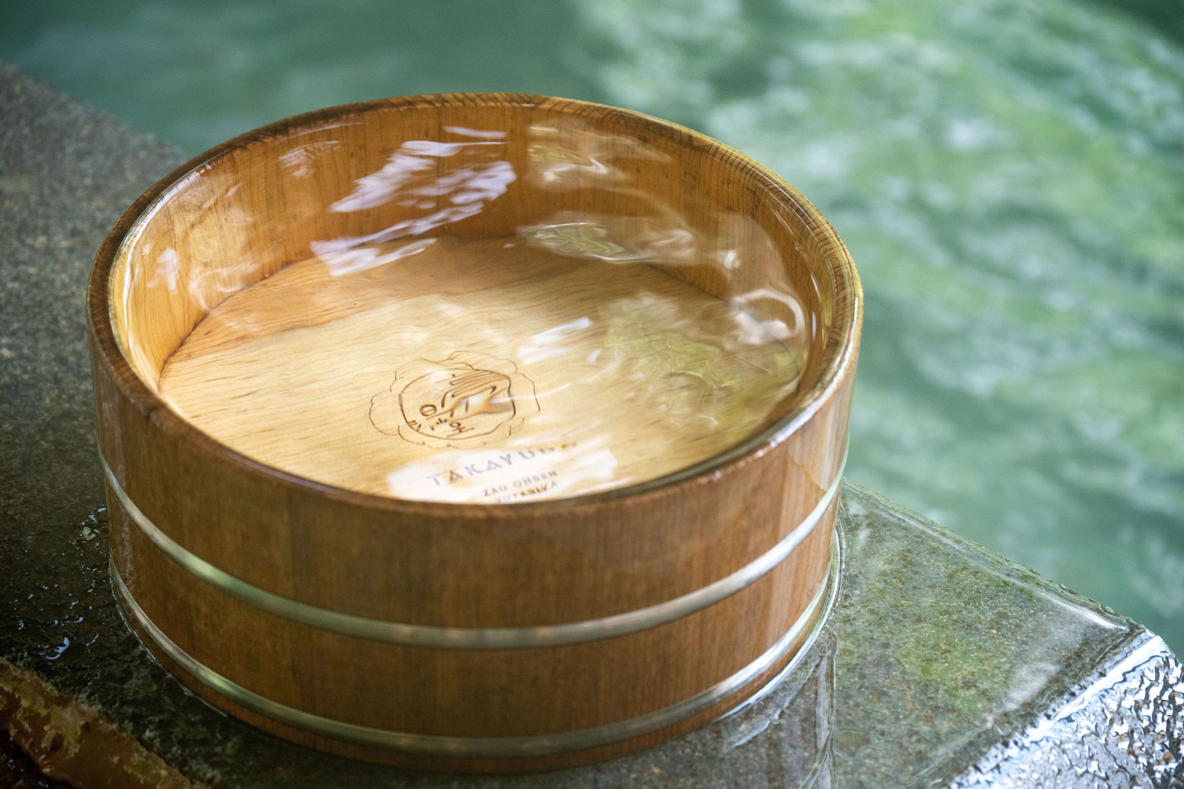 A wooden bowl with a label, placed on a reflective surface.
