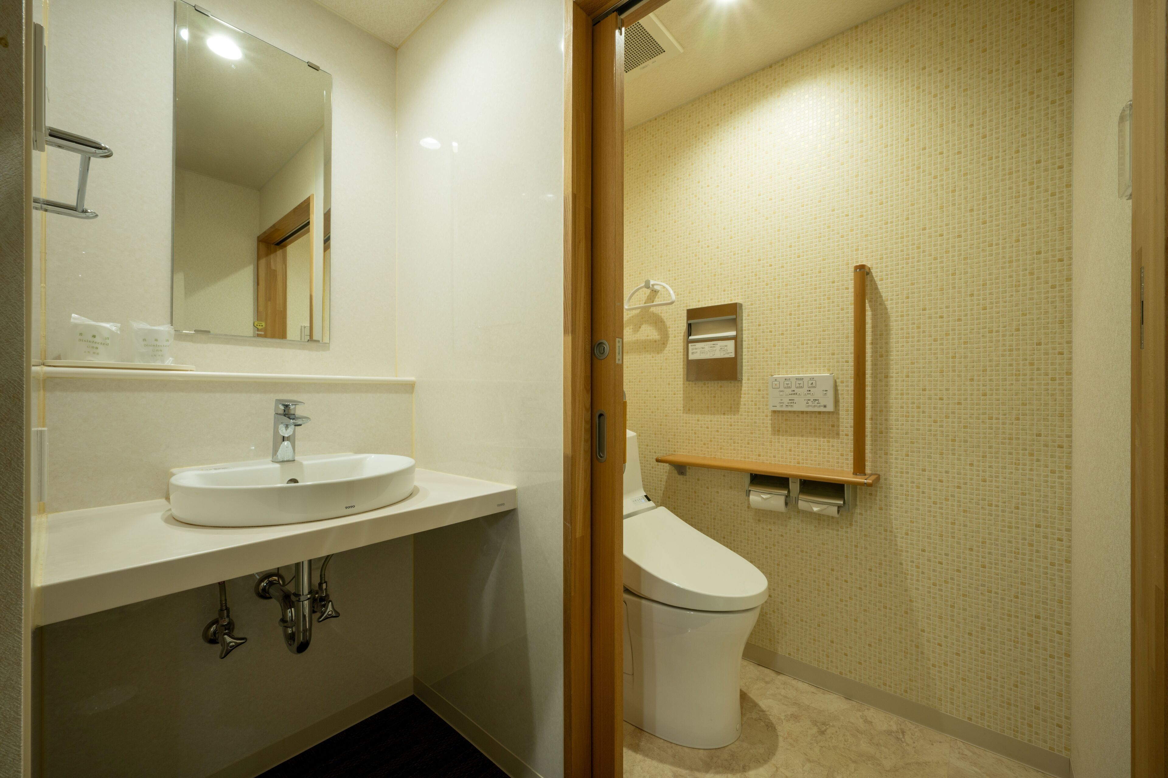 A modern bathroom with a sink, mirror, toilet, and shower area.