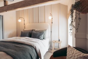 A modern bedroom with a bed, bedside tables, and hanging plants. - The Byre Lake District Retreat By Together Travel (Penrith)