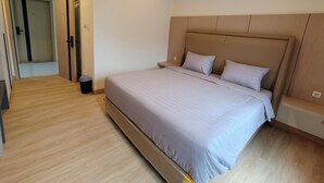 A modern bedroom with a large bed, wooden flooring, and a built-in headboard. - Gobah Homestay G-Home Syariah (Pekanbaru)