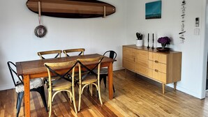 Un coin repas avec une table et des chaises en bois, un buffet en bois et un luminaire suspendu.