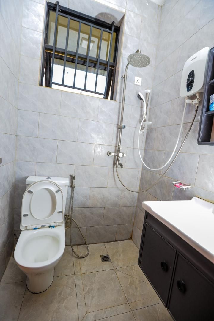 Un baño pequeño con inodoro, ducha y lavamanos.