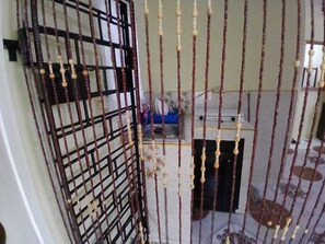A room with a barred gate, a small table with items, and a bed with a white headboard. - Hillview vista (Kingston)