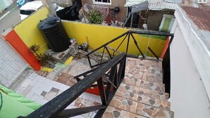 Un escalier recouvert de carreaux de pierre menant à un mur jaune.