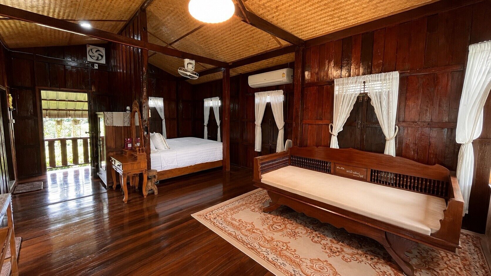 A traditional wooden room with a bed, a bench, and a small table.