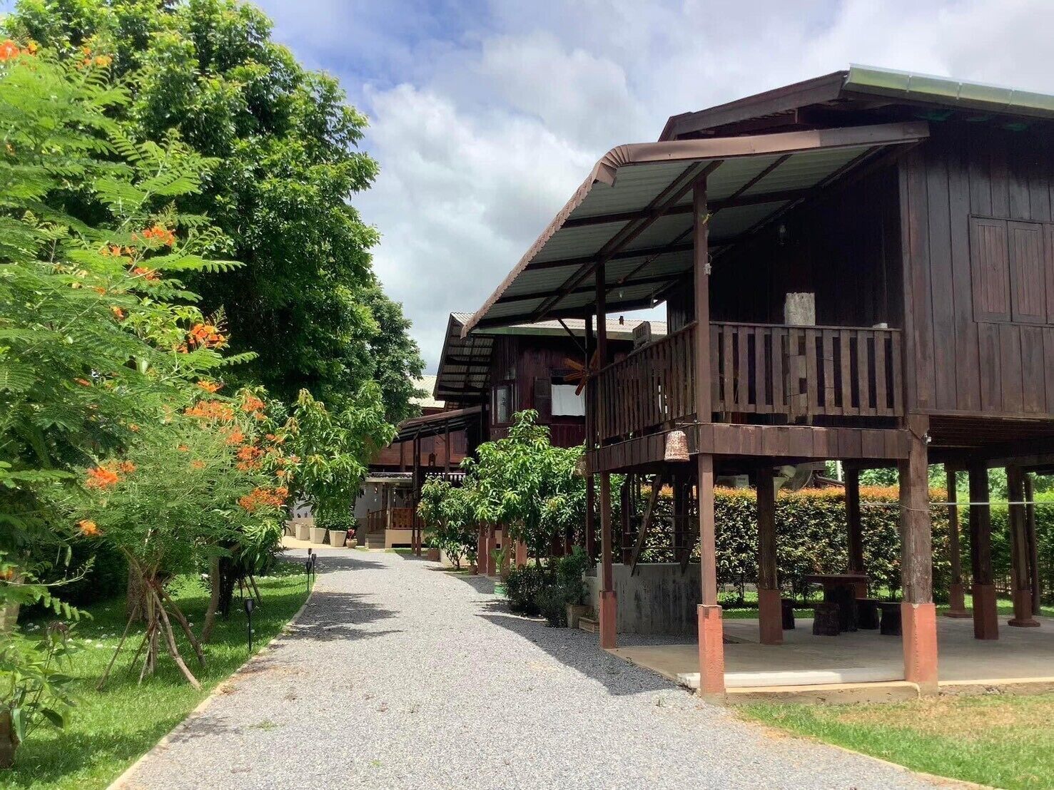 A wooden building with a covered porch and a gravel pathway leading to it.
