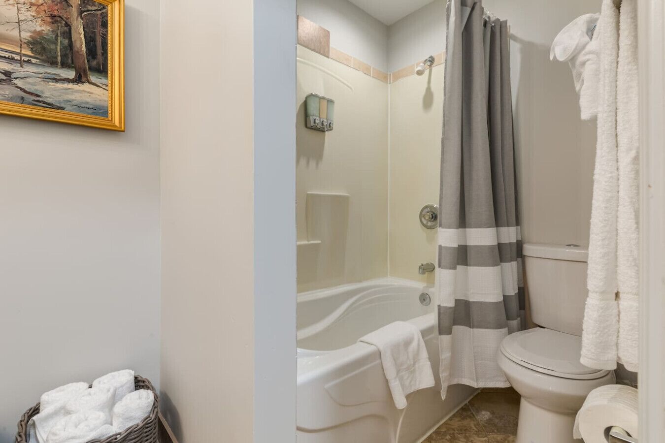 A bathroom with a bathtub, toilet, and shower curtain.