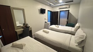 Een hotelkamer met twee bedden, een bureau, een spiegel, een televisie en een airconditioner.