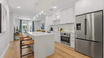 Una cocina moderna con una isla central, electrodomésticos de acero inoxidable y suelo de madera.