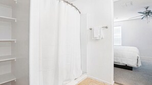 A bedroom with a bed, a white shower curtain, and a ceiling fan. - 4BR Casa Grande Home | Game Table + Large Yard (Casa Grande)