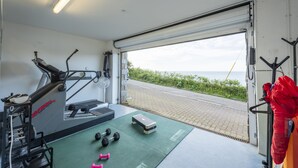 Ein Fitnessstudio mit Trainingsgeräten, Laufband und Kurzhanteln.