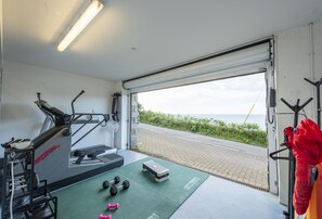 Ein Fitnessstudio mit Trainingsgeräten, Laufband und Kurzhanteln.