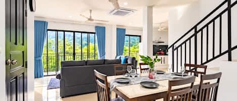 Un interior moderno con comedor, sofá y escalera.