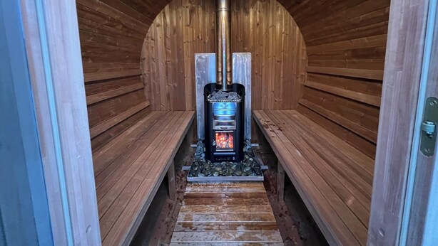 Una sauna con bancos y una unidad de calefacción central.