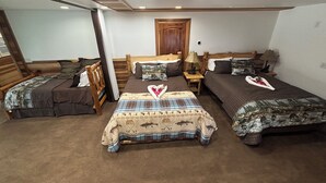 A room with three beds, a wooden headboard, a wooden door, and a nightstand with a lamp. - Fisherman's Suite~Jetted Tub~Optional Indoor Sauna@ Alaska Knotty Pine B&B (Lazy Mountain)