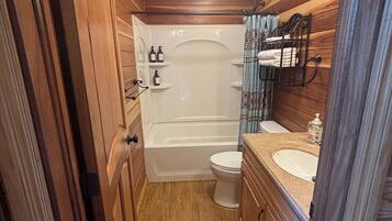 Une petite salle de bain comprenant une baignoire, des toilettes et un lavabo.