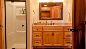 A bathroom with wooden cabinets, a sink, and a mirror.