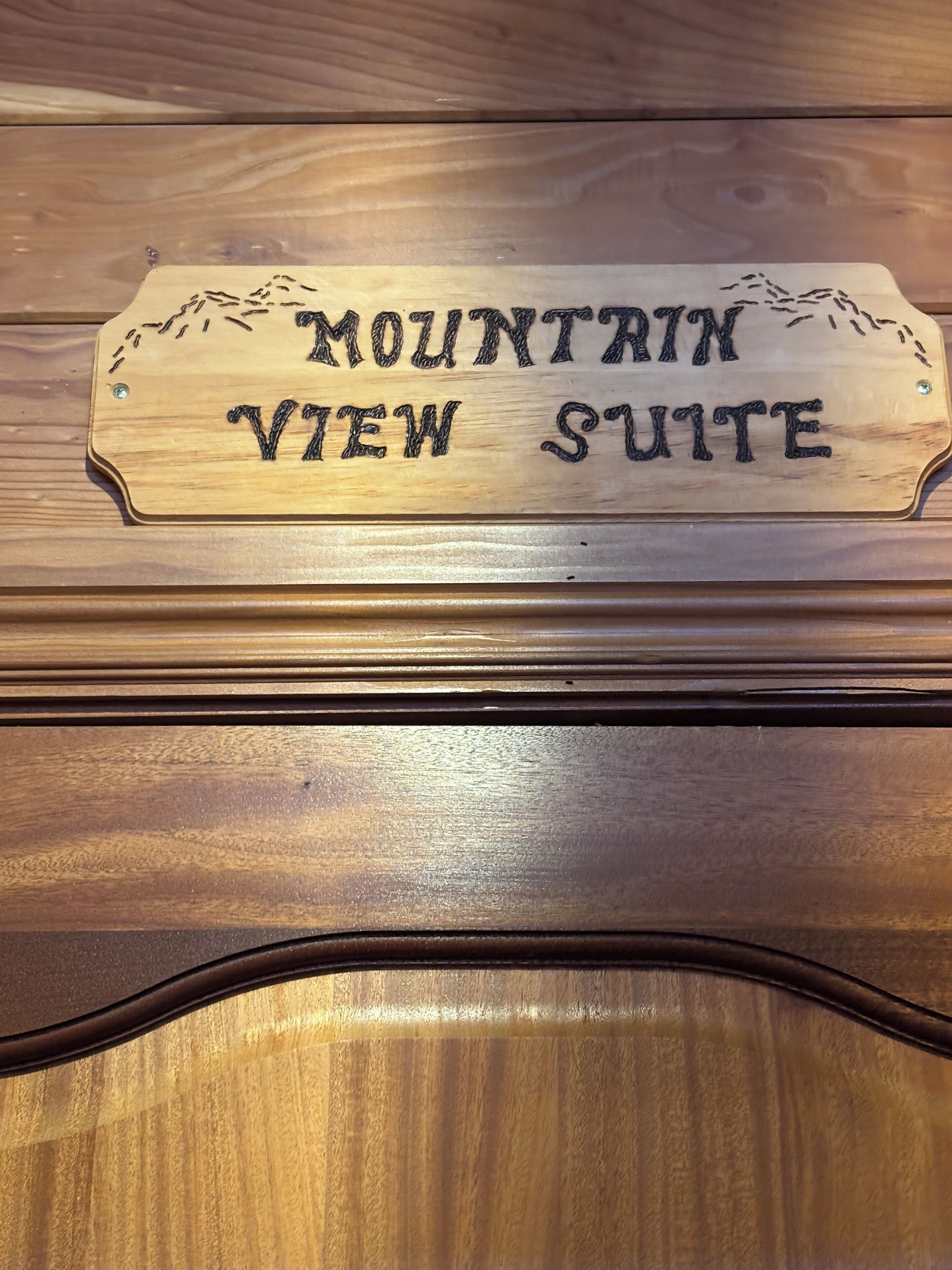 Une plaque en bois portant l’inscription « MOUNTAIN VIEW SUITE », qui indique le nom d’une chambre ou d’une suite.