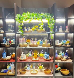 A bathroom with multiple shelves displaying toiletries and decorative plants. - 6 SENSES HOTEL (Hanoi)