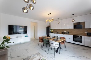 A modern kitchen with a wooden countertop, built-in appliances, and a dining area with a marble floor. - Modern vacation home Izzy - quiet location and close to the beach (Kaštel Štafilić)