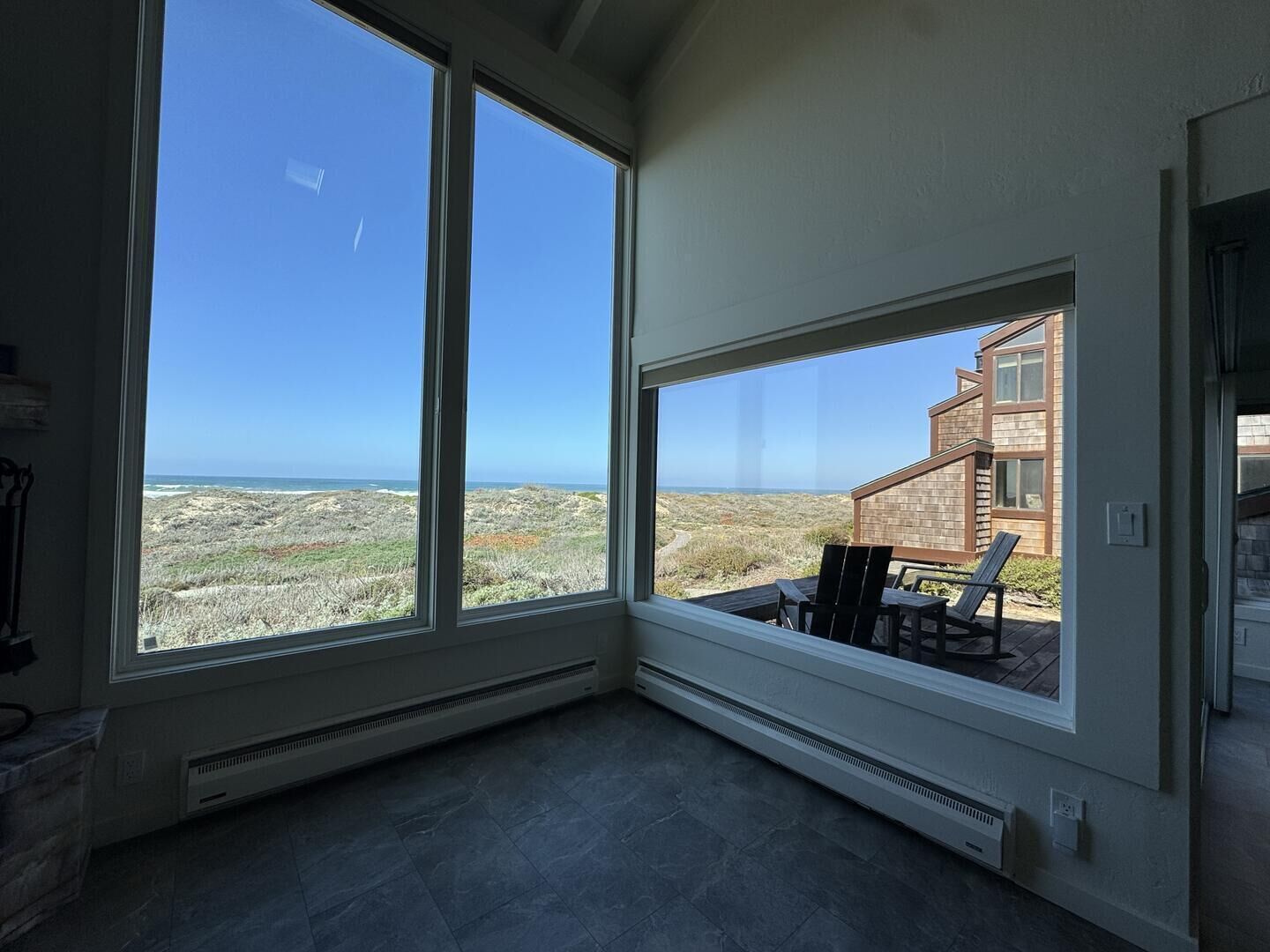 A room with large windows overlooking a coastal landscape.