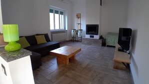 A living room with a sofa, a wooden coffee table, a fireplace, and a television. - At 9 minutes from Milan Malpensa I rent bed with breakfast, pets allowed (Oleggio)