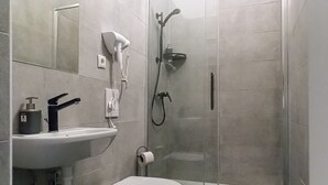 A modern bathroom with a toilet, sink, and shower. - Charming 2BR Apt Near Meidling Station (Vienna)