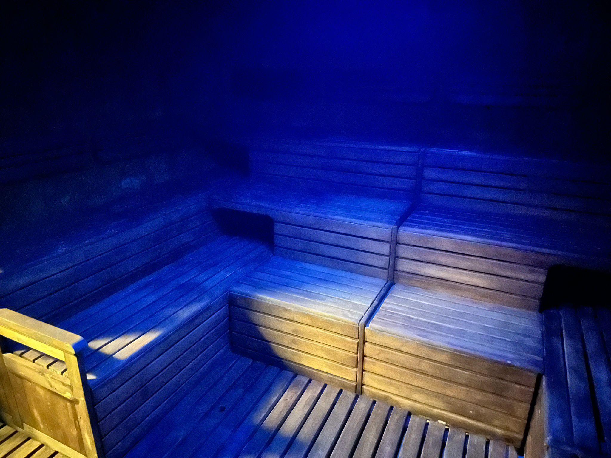 Un sauna avec des bancs en bois et un plancher en bois.