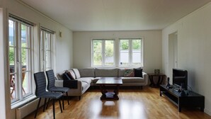 A spacious living room with a large sectional sofa, a coffee table, and a television on a stand. - 8 Person Holiday Home in Adelso (Adelso)