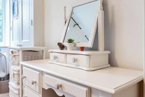 A white dresser with drawers and a mirror.